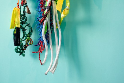 Detail of Liz Miller's knotted rope sculpture on a turquoise green wall.